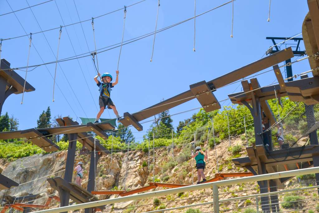 Adventurers tackling the Jordanelle Adventure Ropes Course, featuring physical challenges, aerial obstacles, and stunning views just minutes from Fiori.